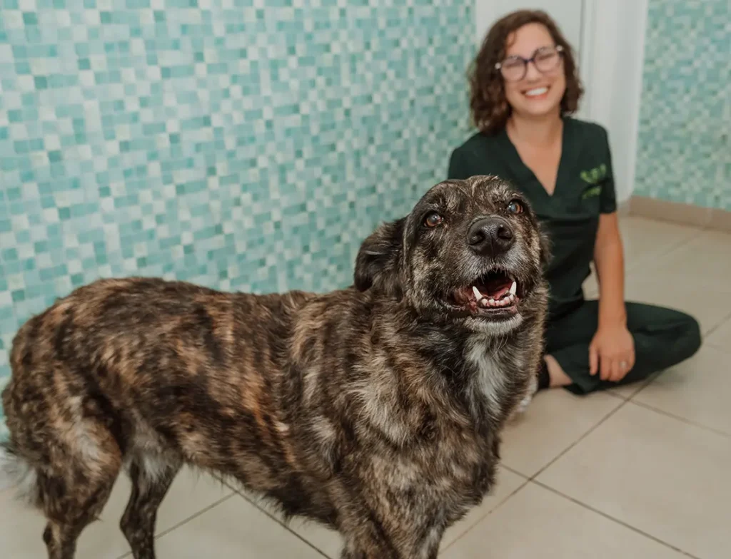 ismene-con-perro-en-clinica Ismene sonriendo con un perro en la clínica